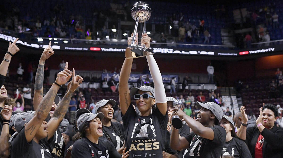 Aces forward A’ja Wilson holds up the WNBA championship trophy with her teammates around her.